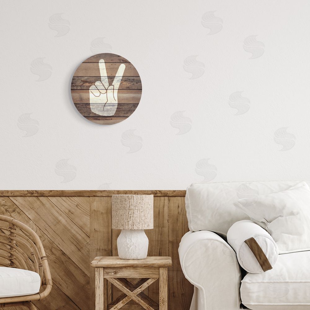 Stupell Studio Peace Hand Rustic Brown Distressed Wood Pattern Round Wall Plaque Art Print in Room
