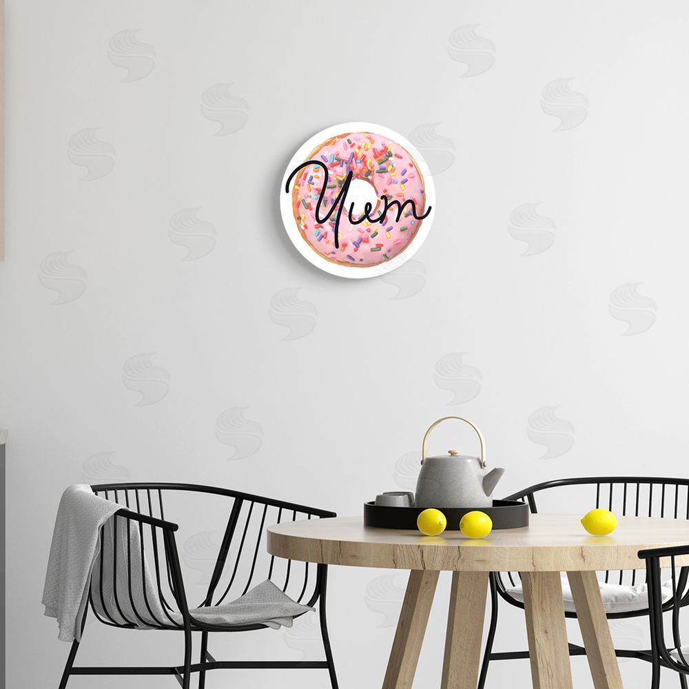 Stupell Studio Yum Phrase Pink Sprinkled Donut Sweet Dessert Round Wall Plaque Art Print in Room