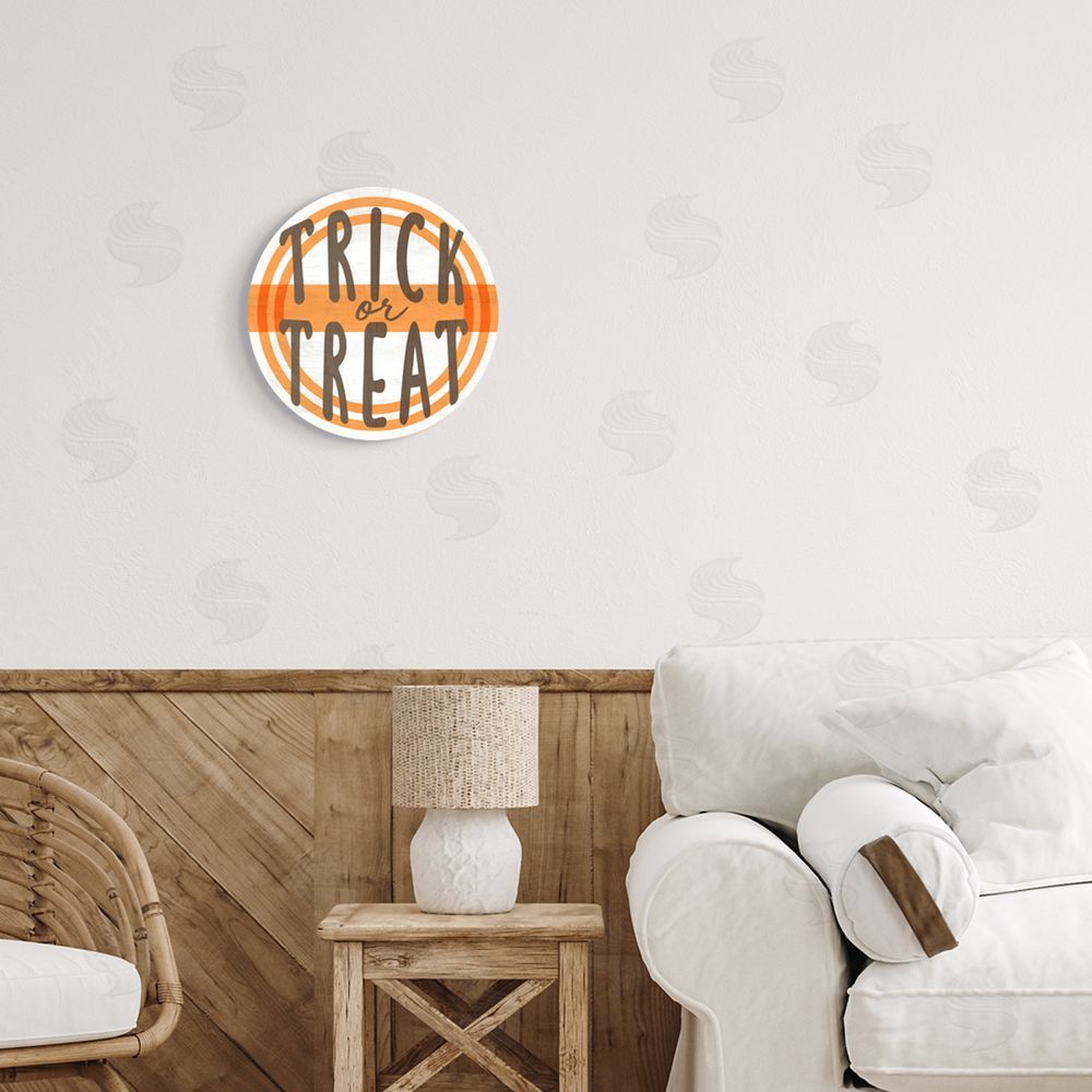 Stupell Studio Orange Trick Or Treat Phrase Round Wall Plaque Art Print in Room